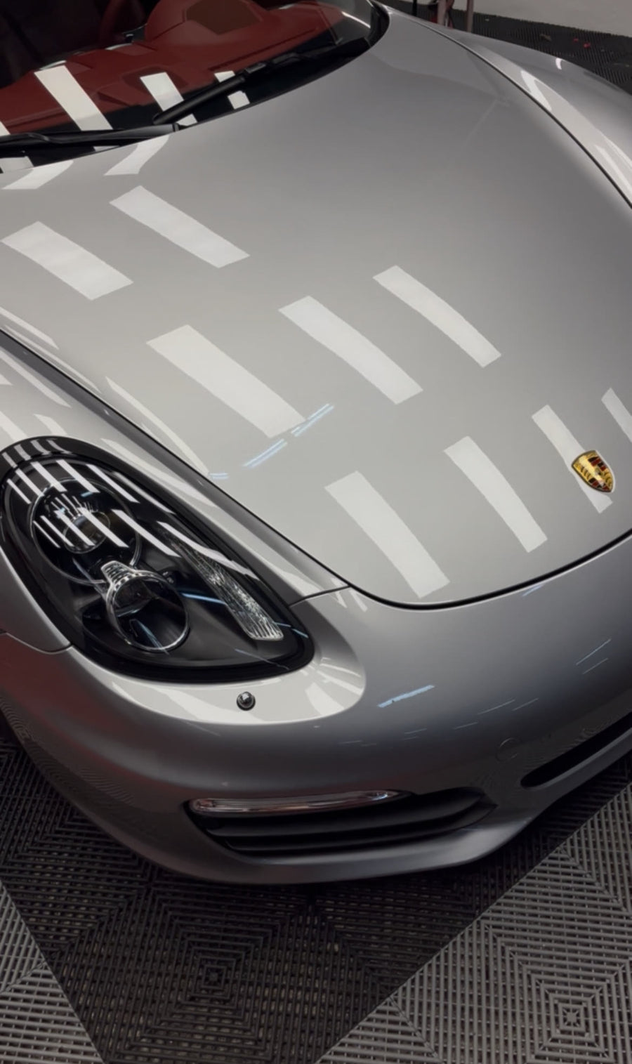 Capó de un Porsche plateado pulido, con reflejos nítidos