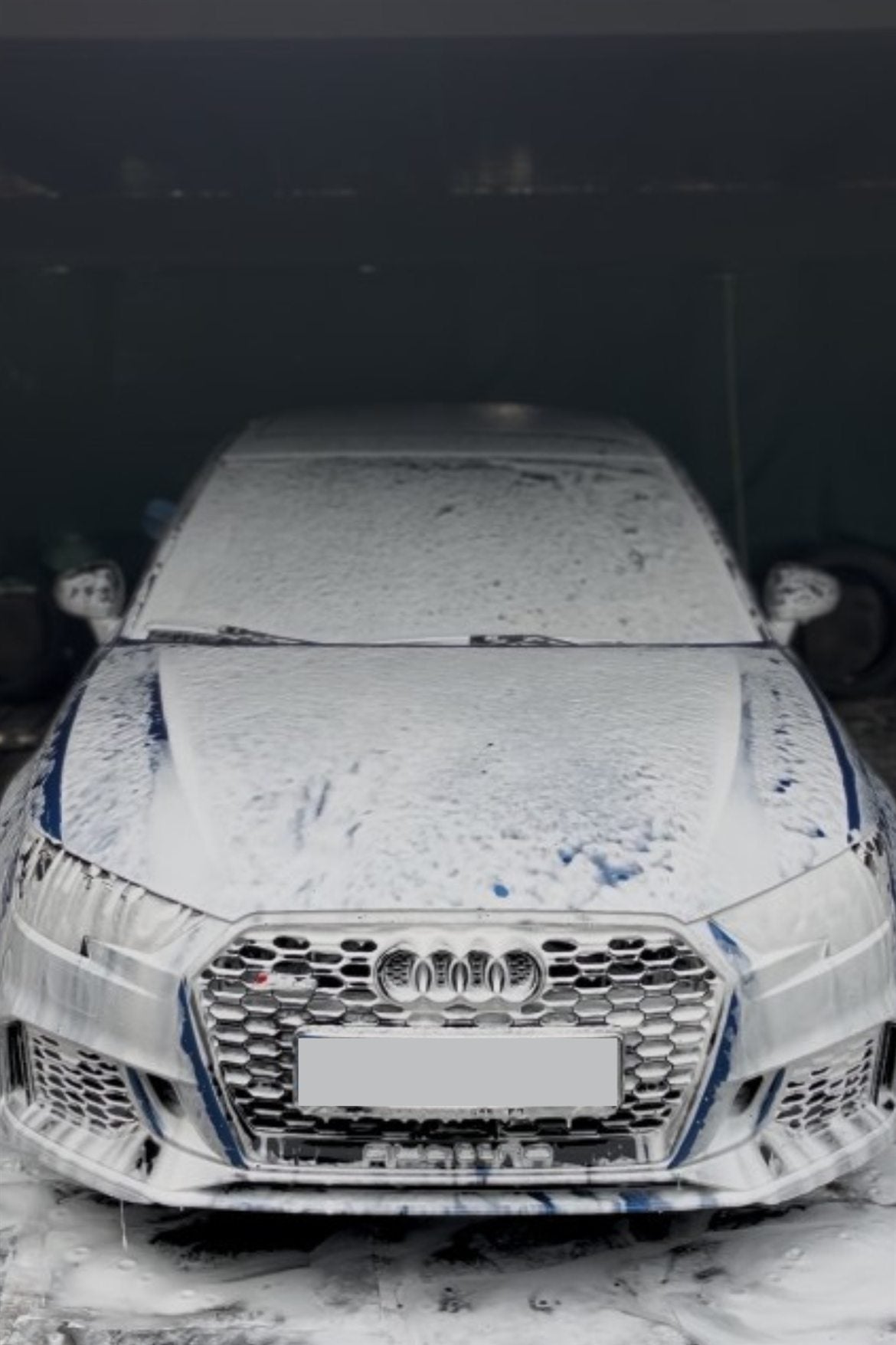 Audi azul cubierto de espuma activa durante el prelavado