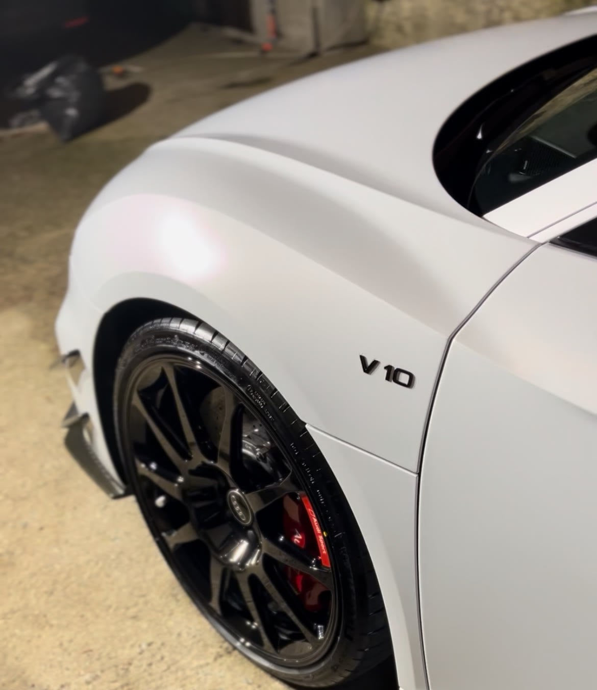 Aleta de un Audi R8 V10 blanco mate con la llanta negra limpia
