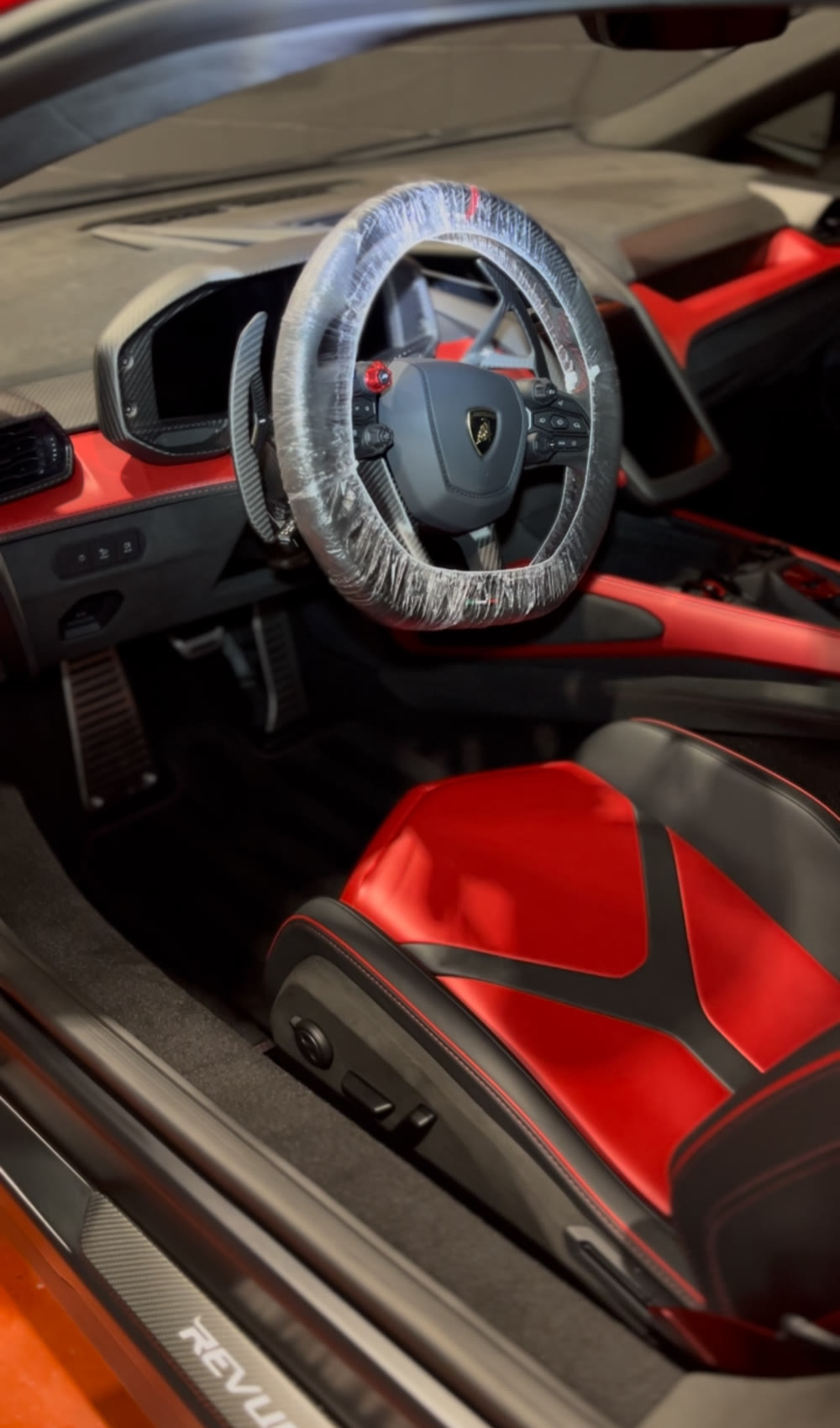 Interior de un Lamborghini Revuelto durante el detallado, con el volante protegido