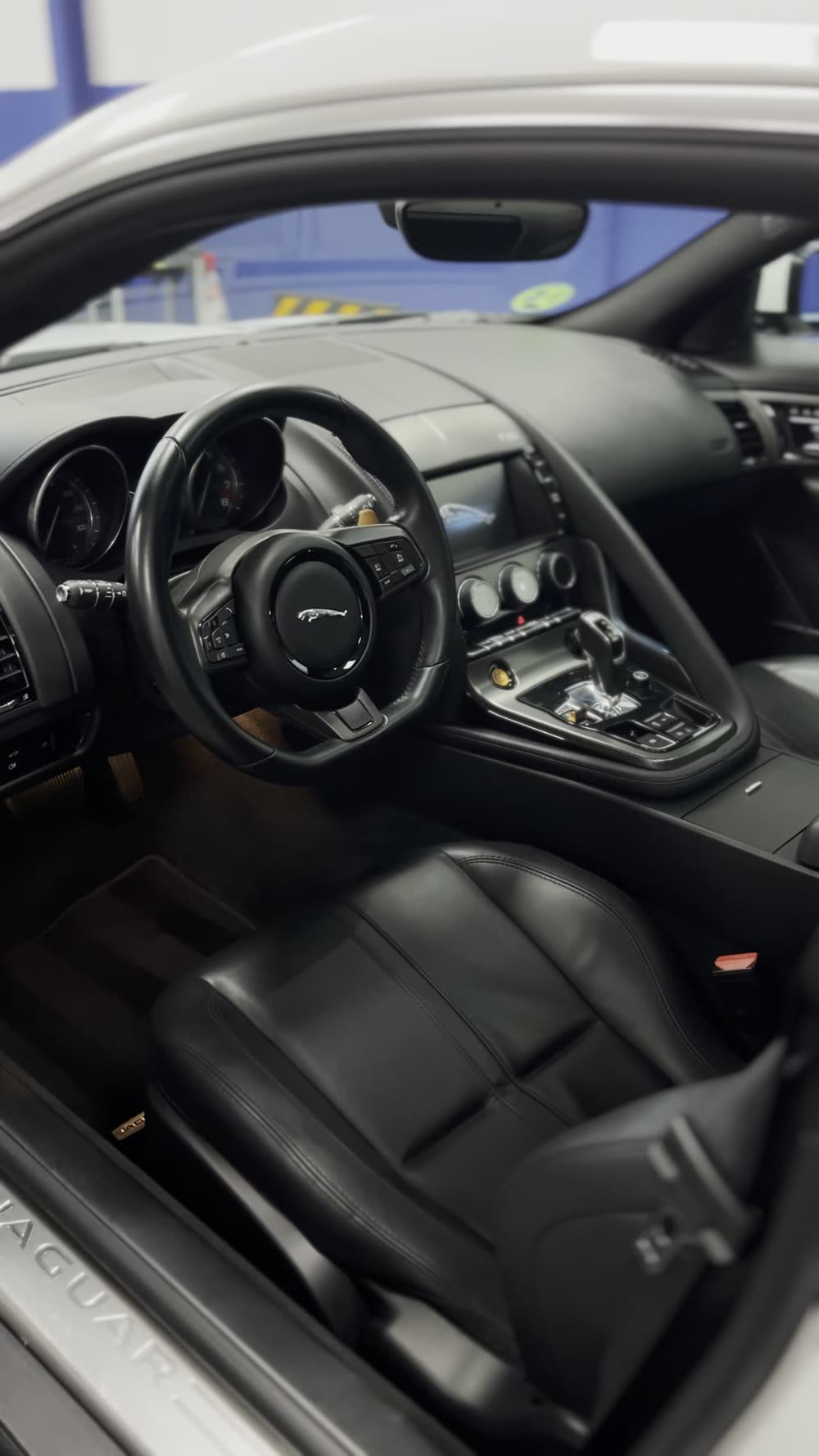 Interior de cuero negro de un Jaguar F-Type durante el detallado