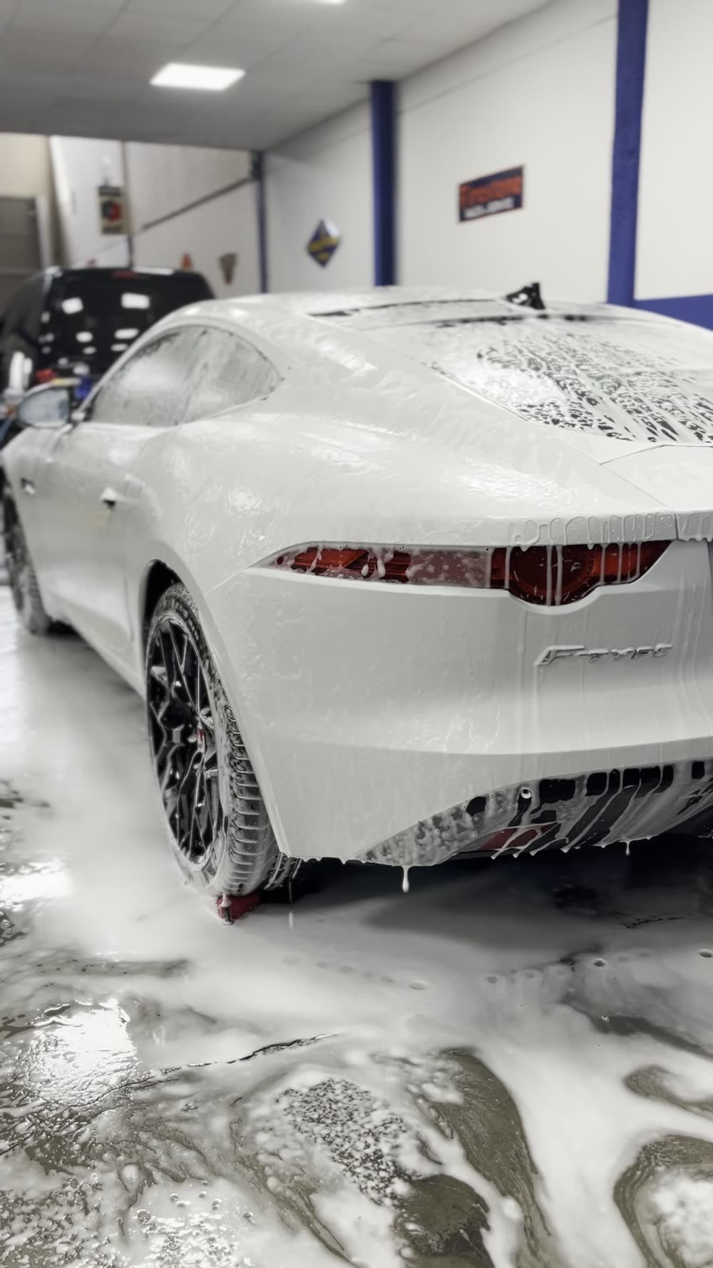 Jaguar F-Type blanco cubierto de espuma durante el prelavado