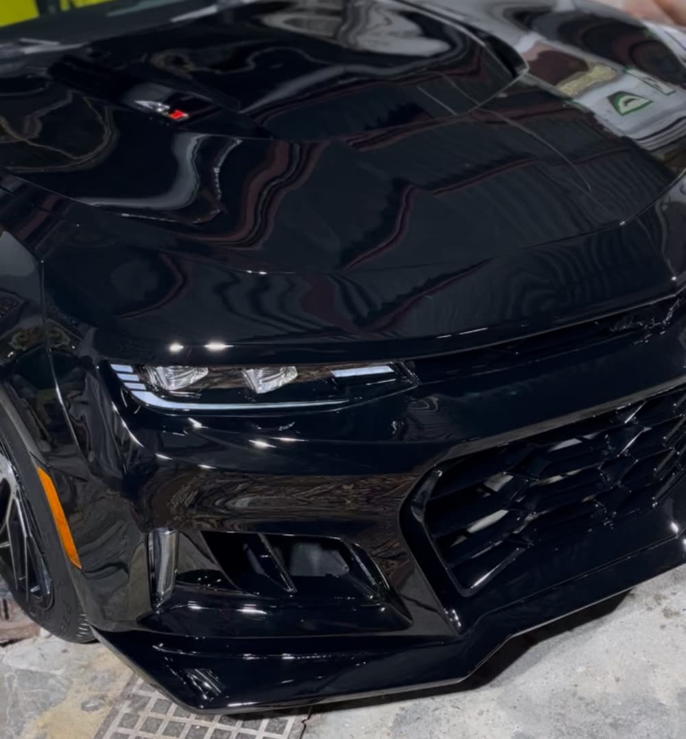 Chevrolet Camaro negro recién pulido, con el capó brillante como un espejo