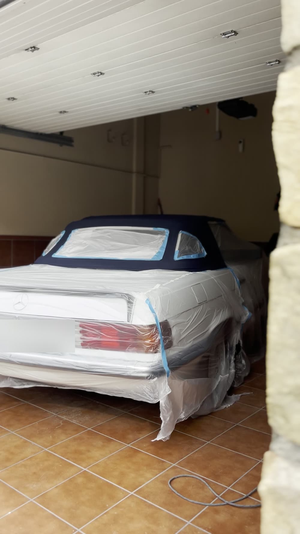 Mercedes SL clásico cubierto y encintado durante el trabajo